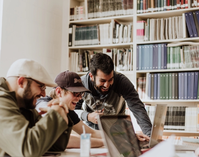 students studying in a room with computers and bookshelves